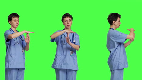 Medical-assistant-giving-timeout-symbol-against-greenscreen-backdrop